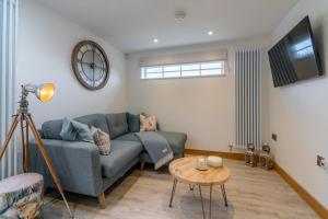 a living room with a blue couch and a table at Hillview Hideaway with Hot Tub in Cheltenham