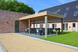 a pavilion with tables and chairs in a yard at Duins Genot 5 star Holiday Homes 30p & 40p - Indoorpool & Wellness in Jabbeke