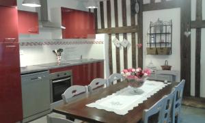 a kitchen with a table with a vase of flowers on it at La petite maison dans la prairie in Notre-Dame-du-Touchet