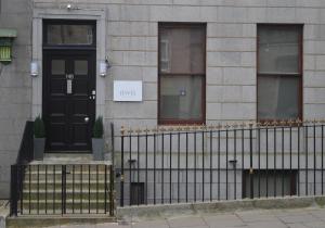 a black door on a building with a fence at Jewel Guest House in Aberdeen