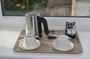 a tea kettle and two cups on a wooden tray at Jewel Guest House in Aberdeen