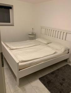 een wit bed in een witte kamer met een bedframe bij Faridd Ferienwohnung in Krefeld
