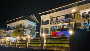 a group of buildings at night with lights at Hill Monk - Whispering Mist in Vagamon