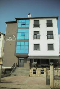 a large white building with glass windows on it at LuxA Apartmani in Novi Pazar