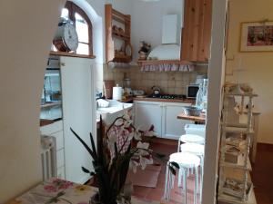małą kuchnię z białymi szafkami i białymi stołkami w obiekcie Casale Cisanello w Pizie