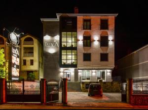 a building with a car parked in front of it at night at LuxA Apartmani in Novi Pazar