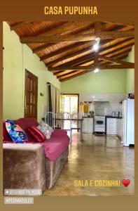 a living room with a couch and a kitchen at Sitio dos Palmitos - Casa Pupunha in Pedra Azul