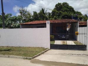 a white fence with a gate in front of a house at Casa Milagres in São Miguel dos Milagres +9 photos