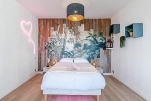 a bedroom with a white bed with a mural on the wall at Appart-Jacuzzi à 6 min de la gare St Charles in Marseille