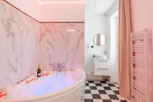 a pink bathroom with a tub and a sink at Appart-Jacuzzi à 6 min de la gare St Charles in Marseille