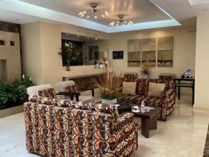 un vestíbulo con sofás, una mesa y un bar en Hotel Magno Tepatitlán, en Tepatitlán de Morelos