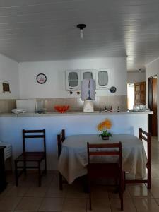 a kitchen with a table and two chairs and a counter at Casa Milagres in São Miguel dos Milagres