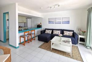 un soggiorno con divano blu e tavolo di Calypso, apartamento completo con vistas al mar y a la piscina en Costa Teguise a Costa Teguise