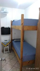 a bedroom with two bunk beds and a television at Quartos no centro de Itu - Hospedagem Elizabeth in Itu