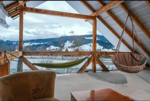 a room with a hammock and a view of a mountain at Сімейна ХаТа in Verkhovyna