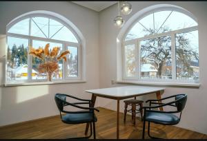 a dining room with a table and two windows at Сімейна ХаТа in Verkhovyna
