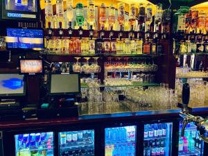 un bar con un montón de botellas de alcohol y vasos en The White Tulip Hostel en Ámsterdam