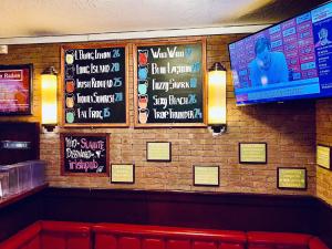a bar with signs on the wall of a restaurant at The White Tulip Hostel in Amsterdam