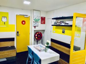 a room with a table and a yellow door at The White Tulip Hostel in Amsterdam