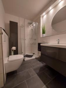 a bathroom with a toilet and a sink and a tub at Berg-Blick-Fewo in Bad Harzburg