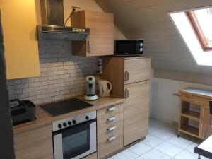 a kitchen with wooden cabinets and a stove top oven at Ferienwohnung am Viadukt in Wald-Michelbach