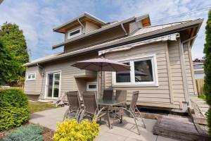 a table and chairs with an umbrella in front of a house at West Coast Luxury Living in Vancouver