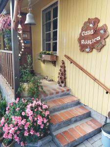 a set of stairs leading to a house with flowers at Casa Rústica - Hospedaria in Canela