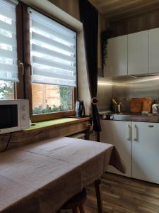 a kitchen with a table and a microwave and a window at Marynka in Zakopane