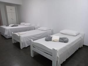 two beds with white sheets and towels on them in a room at PLANALTO HOTEL II in Arujá