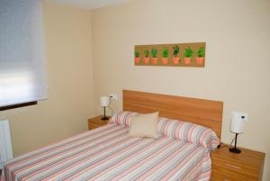 a bedroom with a bed and a striped couch at Residencial Massana in Alcalá de la Selva