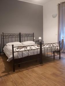 un letto nero in una camera da letto con pavimento in legno di Marco E Laura a Roma