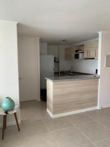 a kitchen with a counter top and a refrigerator at Departamento Vista al Mar, primera línea in Coquimbo
