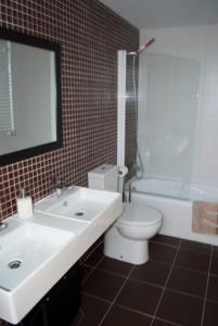 a bathroom with a white sink and a toilet at Residencial Massana in Alcalá de la Selva