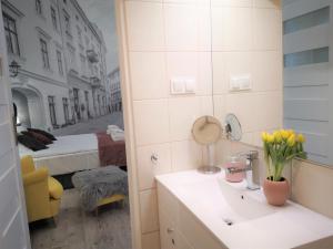 a bathroom with a sink and a bedroom with a bed at ZamStudio Kraków Zamenhofa 4 in Krakow