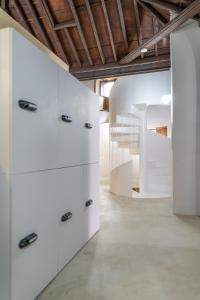 Habitación con cajones blancos y escalera. en HosteLit, Capsule Hostel en Santa Cruz de la Palma