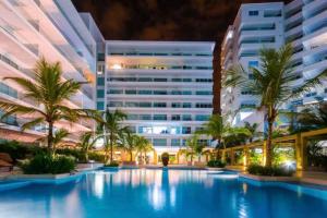 un hotel con piscina frente a un edificio en Hermoso apartamento con todas las comodidades acceso directo a la playa Morros Epic sector La Boquilla cumple protocolos de bioseguridad en Cartagena de Indias