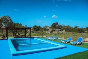 a swimming pool with chairs and a gazebo at Ecohotel Shalom in Valladolid