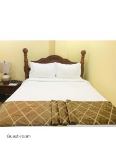 Una cama con sábanas blancas y almohadas en un dormitorio en Essentials Suite, en Bon Accord