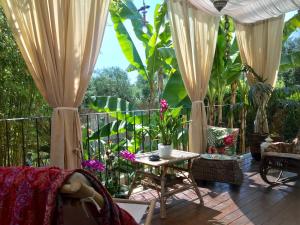 a patio with curtains and a table and chairs at villa Giada in Vallecchia