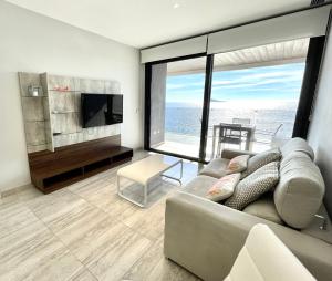 a living room with a couch and a television at Exclusive Apartments on the first line of Benidorm Mar y Sol in Benidorm