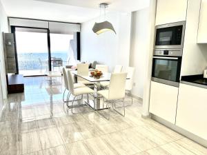 a kitchen and dining room with a table and chairs at Exclusive Apartments on the first line of Benidorm Mar y Sol in Benidorm