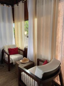 a room with a crib and a chair and a window at Pousada Potigua in Maricá