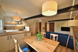 eine Küche und ein Esszimmer mit einem Holztisch und Stühlen in der Unterkunft Landidyll Hotel Klostermühle in Münchweiler an der Alsenz