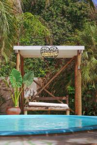 une pergola en bois avec un panneau au-dessus de la piscine dans l'établissement Tropical Hostel, à Pipa
