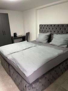 Schlafzimmer mit einem großen Bett mit einem gepolsterten Kopfteil in der Unterkunft All In in Oberhausen