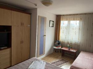 a bedroom with a bed and a tv and a window at Cazare ieftina in Piatra Neamţ
