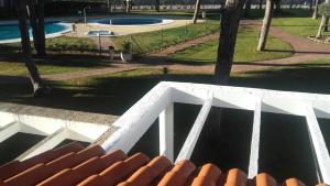 vistas a la piscina y a un puente blanco en Primera línea de playa casita adosada en Chiclana de la Frontera
