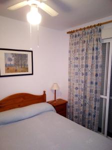 1 dormitorio con cama y ventana en Primera línea de playa casita adosada en Chiclana de la Frontera