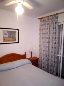 a bedroom with a bed and a window at Primera línea de playa casita adosada in Chiclana de la Frontera