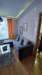 a living room with a couch and a table at apartman Kraljevi čardaci Sadikovic sa garažom in Kopaonik